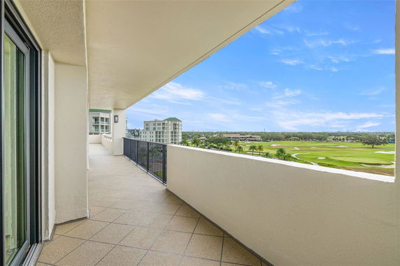 View from a balcony overlooking golf course and buildings.