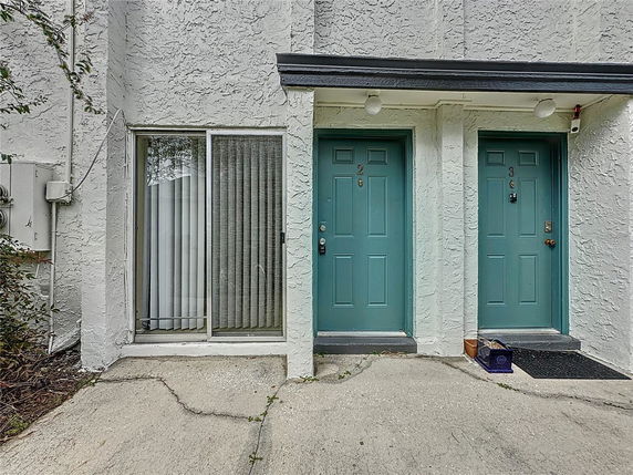 Front view of a building with two teal-colored doors labeled 2 and 3, and a glass sliding door on the left.