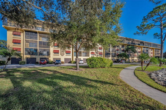 Front view of a multi-story residential building with balconies and awnings.