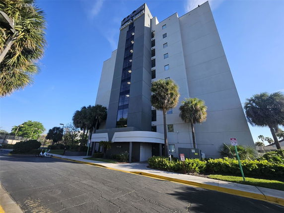 Front view of a multi-story building with palm trees