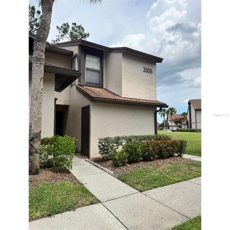Front view of a two-story house with a brown roof and beige exterior.
