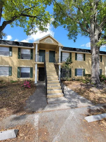 Front view of a two-story residential building with an external staircase.