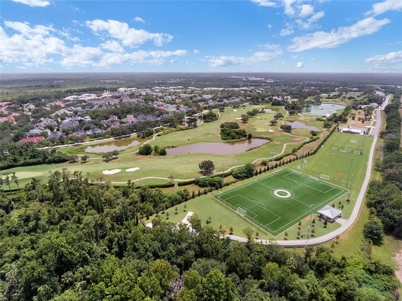 Panoramic view of a developed area with houses, golf course, and sports fields.