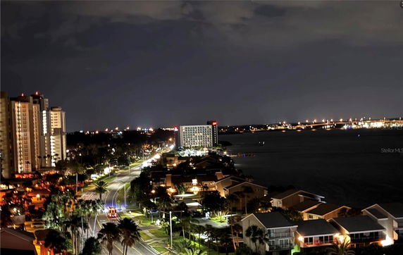Nighttime panoramic view of city buildings and waterfront.