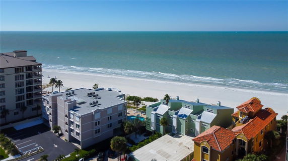 View of a beachfront with buildings and ocean in the background.