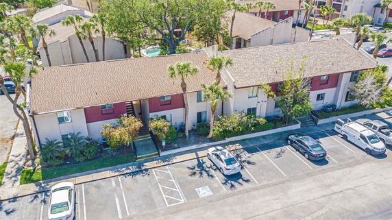 Front view of a two-story apartment building with parking spaces.