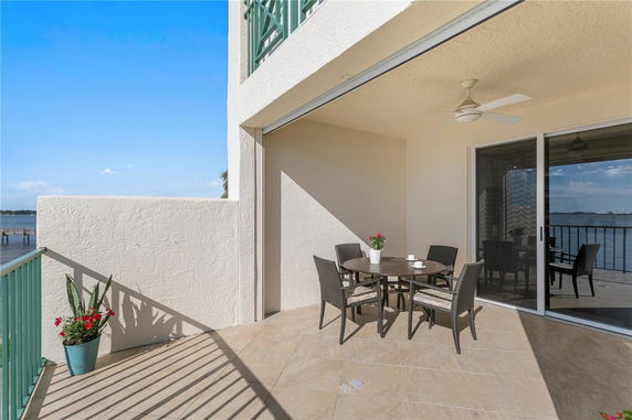 Outdoor patio with table and chairs overlooking a water view.