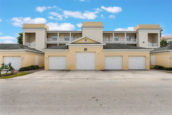 Front view of a multi-story building with garages on the ground level and balconies above.