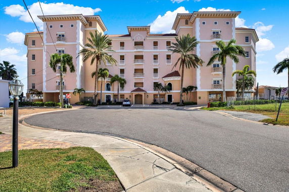 Front view of a multi-story residential building with balconies and a central entrance.