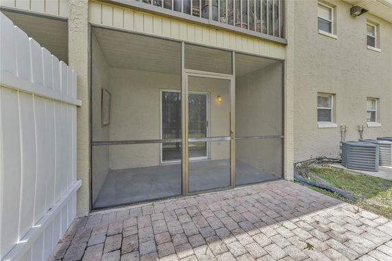 Rear view of a house with a screened-in patio area.