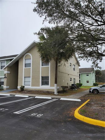 Front view of a multi-story building with large windows and a sloped roof.