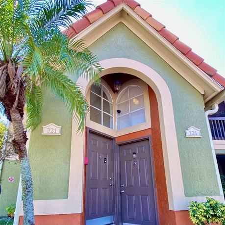 Front view of a house with dual entry doors and arched windows.