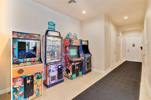 Interior hallway with arcade machines and restrooms signage.
