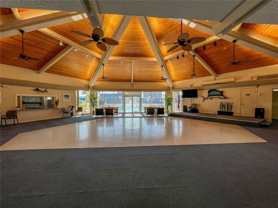 Spacious indoor clubhouse with a wooden ceiling and ceiling fans.