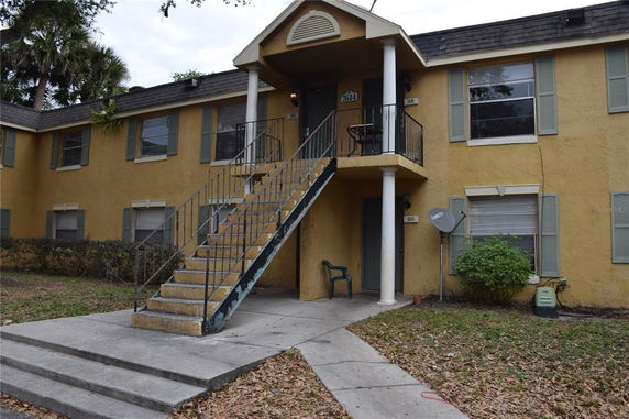 Front view of a two-story apartment building with an exterior staircase.