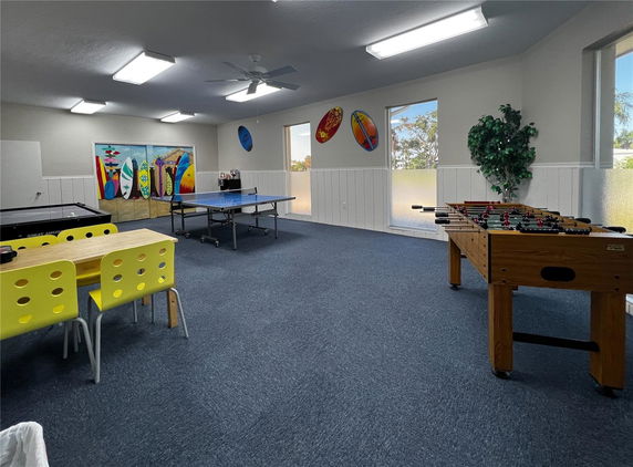 Room with table tennis, foosball table, and surfboards on the walls.
