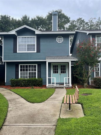 Front view of a two-story house with blue siding and a small porch.