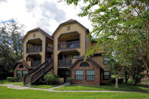 Front view of a multi-story residential building with external staircases and balconies.