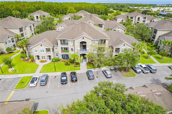 Aerial view of a residential complex with multiple apartment buildings and parking spaces.