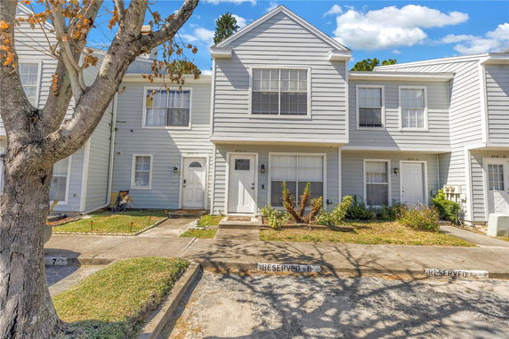 Front view of a two-story townhouse with white siding.