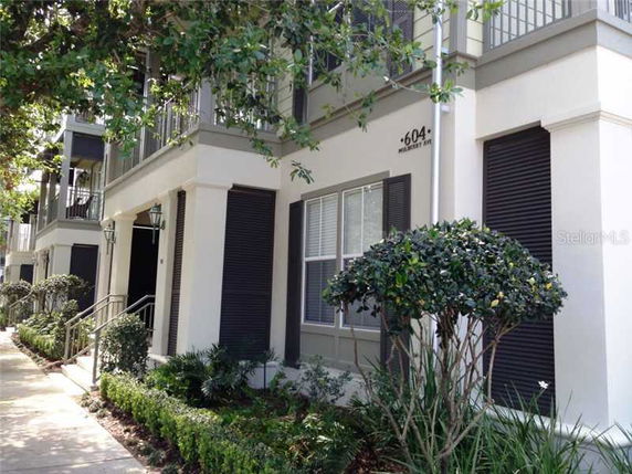 Front view of a multi-story building with balconies and large windows.
