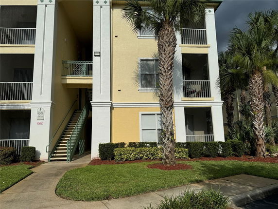 Front view of a multi-story building with balconies and an exterior staircase.