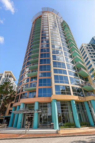 Front view of a high-rise building with large windows and balconies.