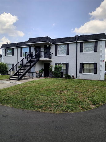Front view of a two-story house with an external staircase.