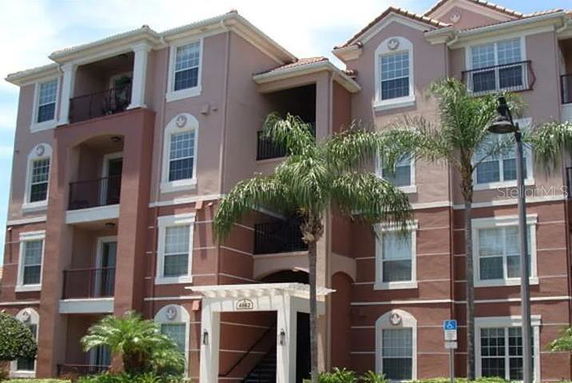 Front view of a multi-story residential building with balconies and arch details.