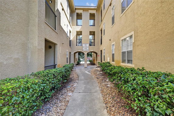 Front view of a multistory apartment building with a walkway.