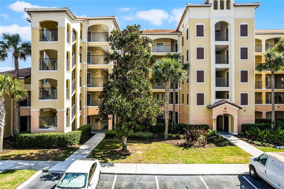 Front view of a multi-story residential building with balconies and an entrance.