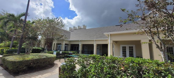 Front view of a building with a sloped roof and patio.