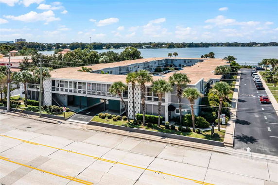 Front view of a multi-story building with a flat roof and balconies.