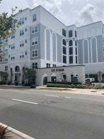 Front view of a multi-story apartment building with decorative arches and detailed facade.
