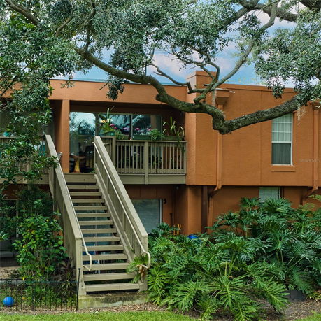 Front view of a two-story house with an external staircase and balcony.