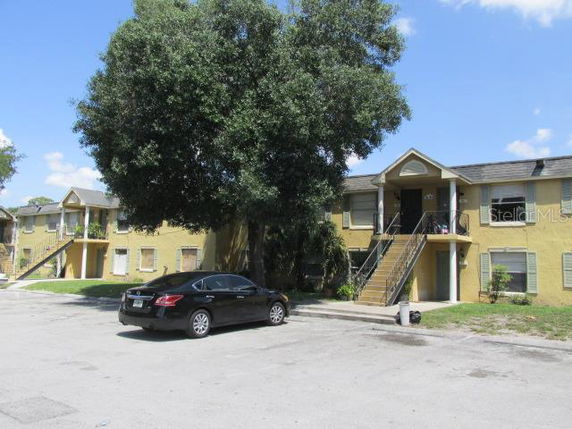 Front view of a two-story apartment building with stairs leading to the upper level.