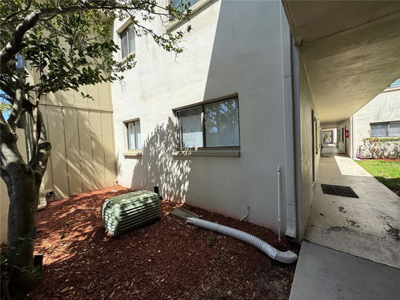 Side view of a building with multiple windows and a covered walkway.