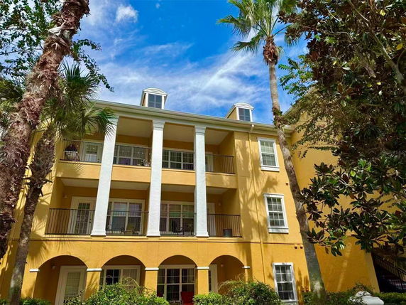Front view of a three-story building with balconies and columns.