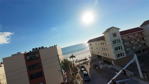 Panoramic view of the ocean and beach with buildings in the foreground.