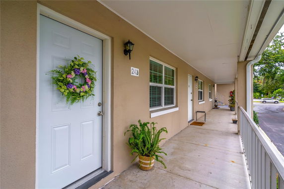Front view of a building's entrance with doors and windows along a covered walkway.
