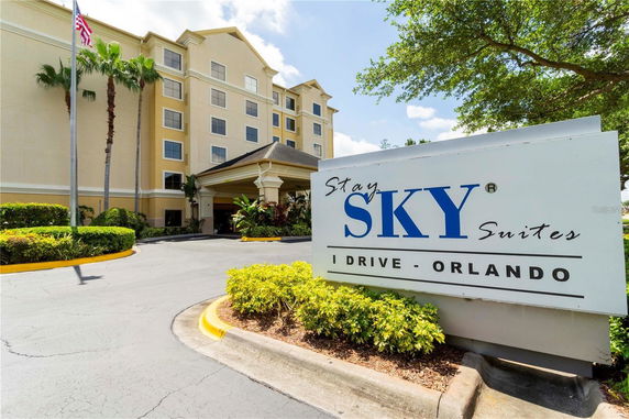 Front view of a multi-story hotel with a driveway and entrance.