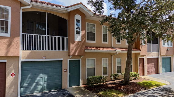 Front view of a two-story townhouse with a garage and a balcony.