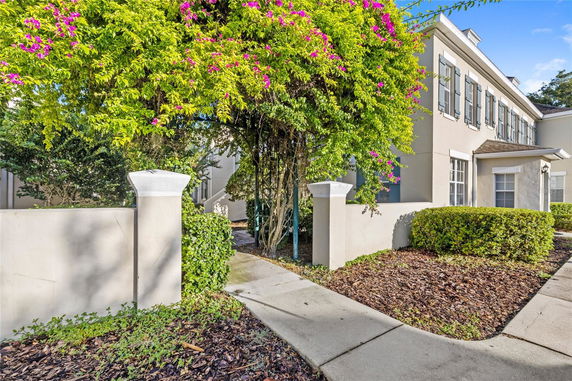 Front view of a two-story house with shutters and a small garden area.