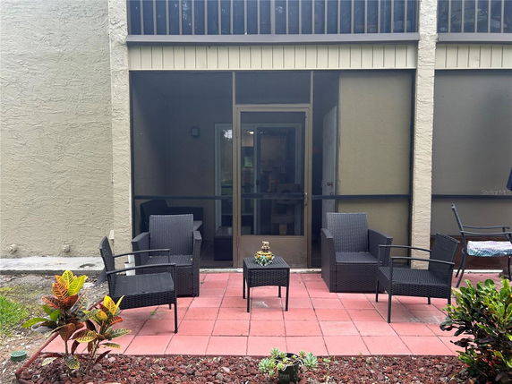 Outdoor seating area with wicker chairs and a small table on a patio.