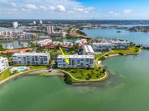 Aerial view of residential buildings surrounded by water and greenery