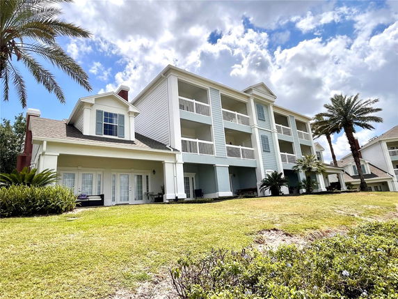 Front view of a multi-story building with balconies and a covered porch.