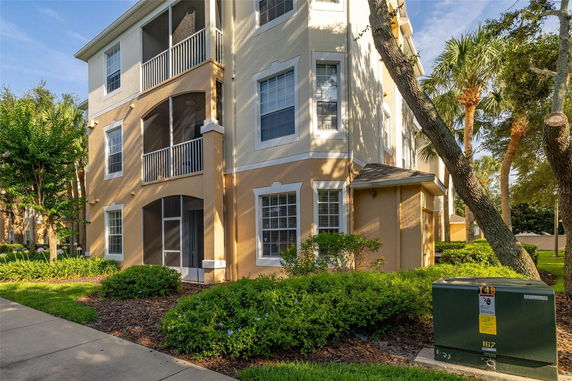 Front view of a three-story residential building with screened balconies.