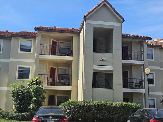 Front view of a three-story apartment building with balconies.
