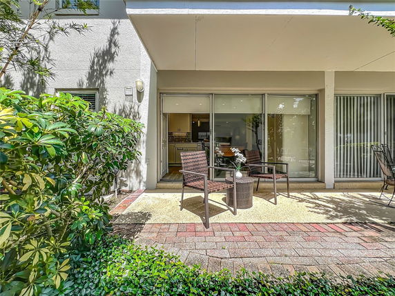 Front view of a house with a small patio and sliding glass doors.