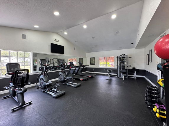 Indoor gym area with exercise machines and weights.